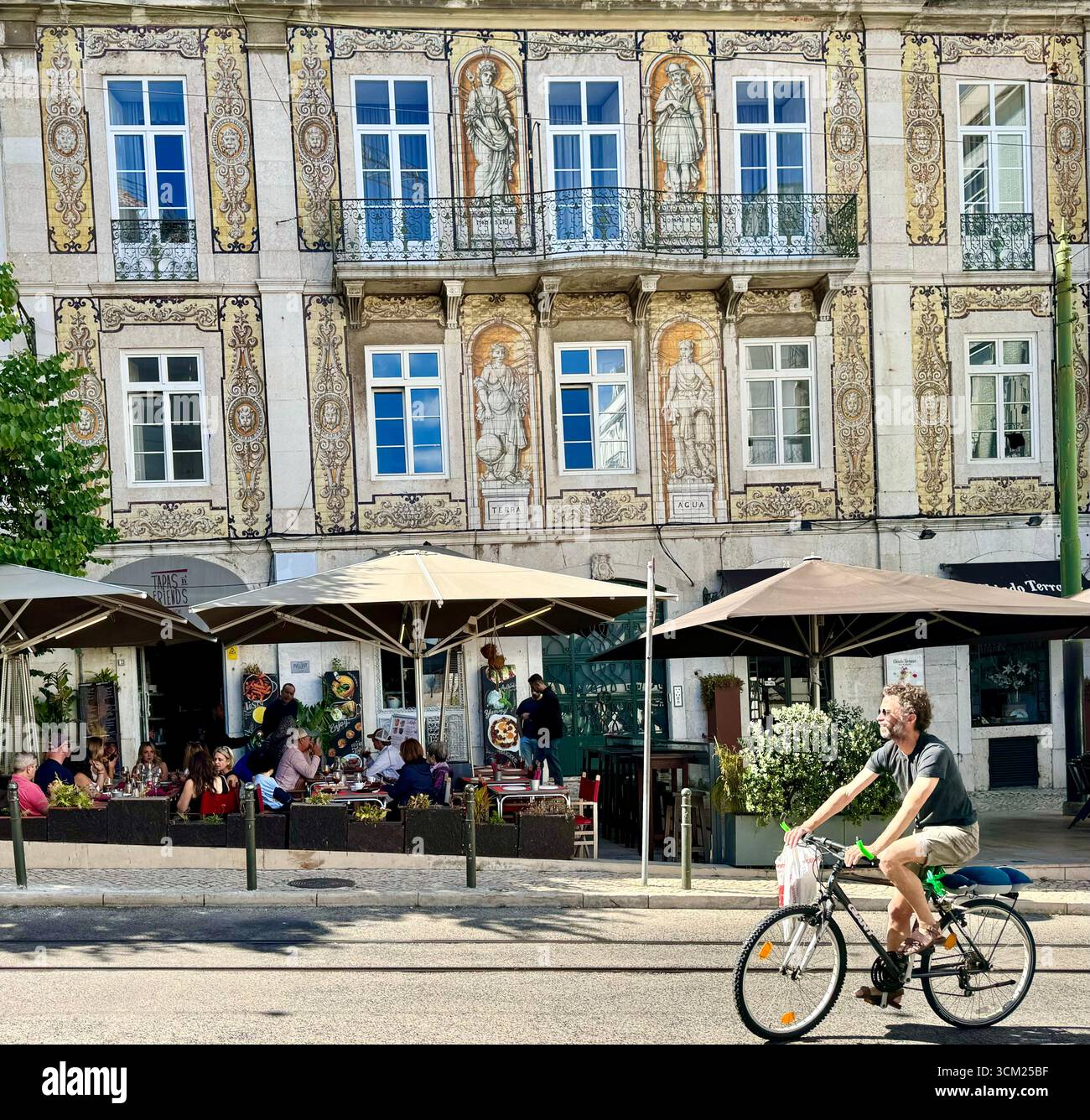 Cyclist riding bike in front of Casa do Ferreira das Tabuletas, Ferreiras House of the Tablets, Lisbon Portugal - Smartphone Captured Stock Image