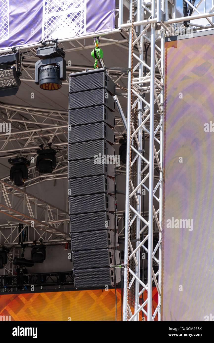Linear array of powerful speakers on an outdoor concert stage, ready ...
