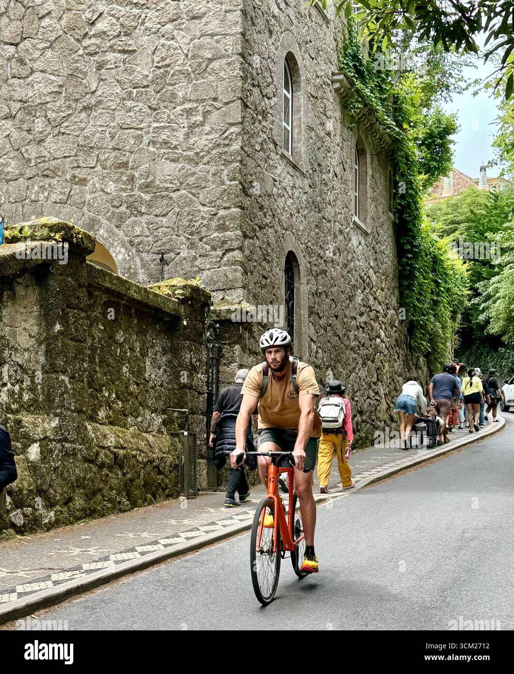 Cyclist riding a bike on ride by Quinta da Regaleira manor house in World Heritage Site  of Sintra Portugal - Smartphone Captured Stock Image