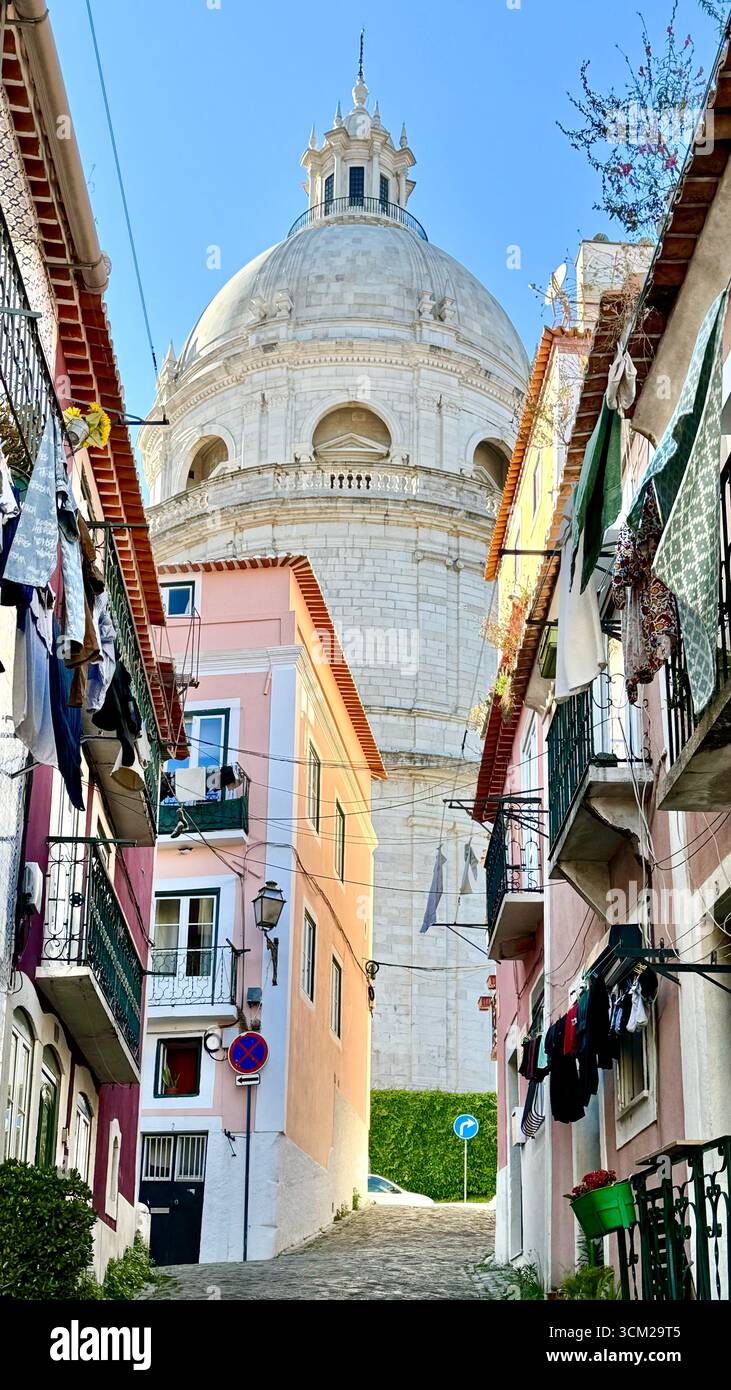 Laundry hanging on clothes lines off balconies on Travessa do Paraiso in Alfama with Dome of National Pantheon  Lisbon Portugal - Smartphone Captured Stock Image