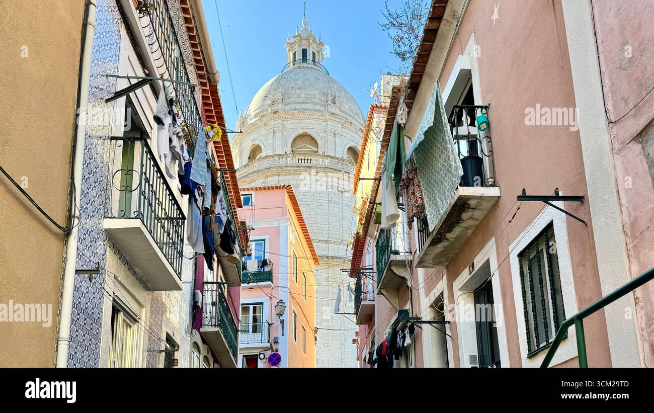Laundry hanging on clothes lines off balconies on Travessa do Paraiso in Alfama with Dome of National Pantheon  Lisbon Portugal - Smartphone Captured Stock Image
