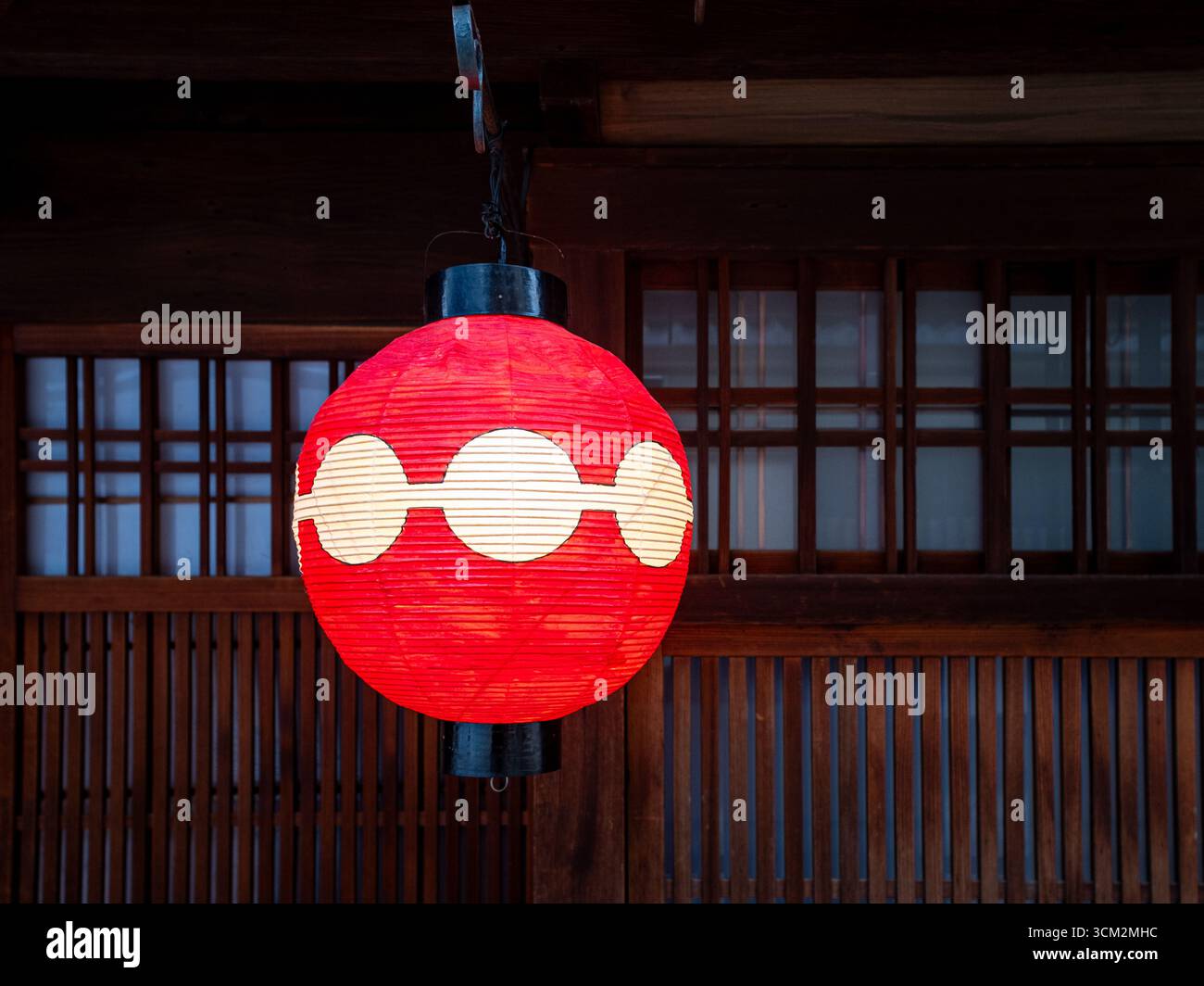 A red traditional japanese lantern in Kyoto on a dark background made of wood and small windows Stock Photo