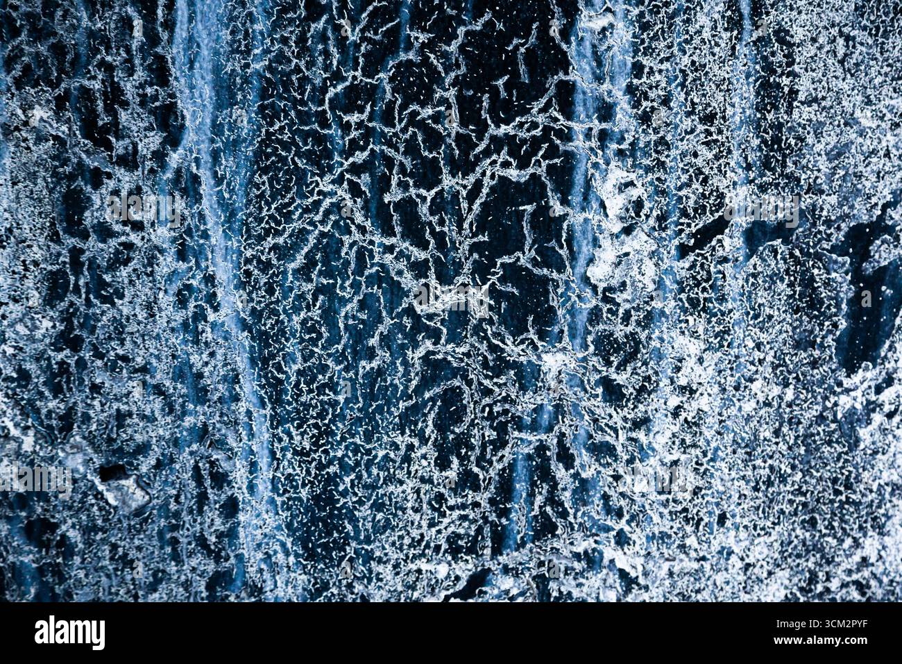Frozen water with various ice patterns, cracks and drips. Stock Photo