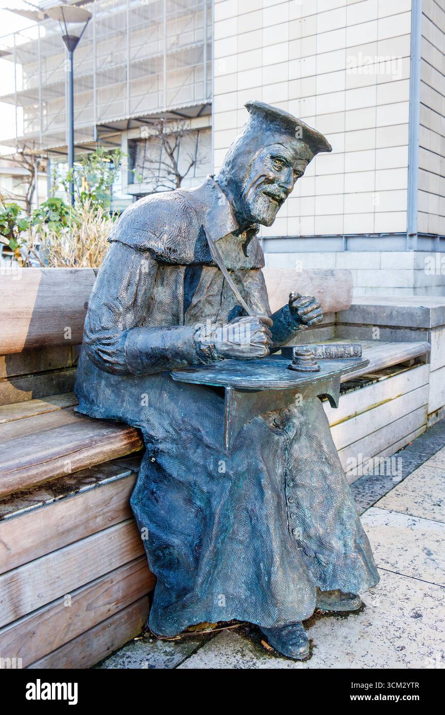 Bronze statue of a William Tyndale, first translator of the Bible into modern English in a seated position millenium square bristol Stock Photo