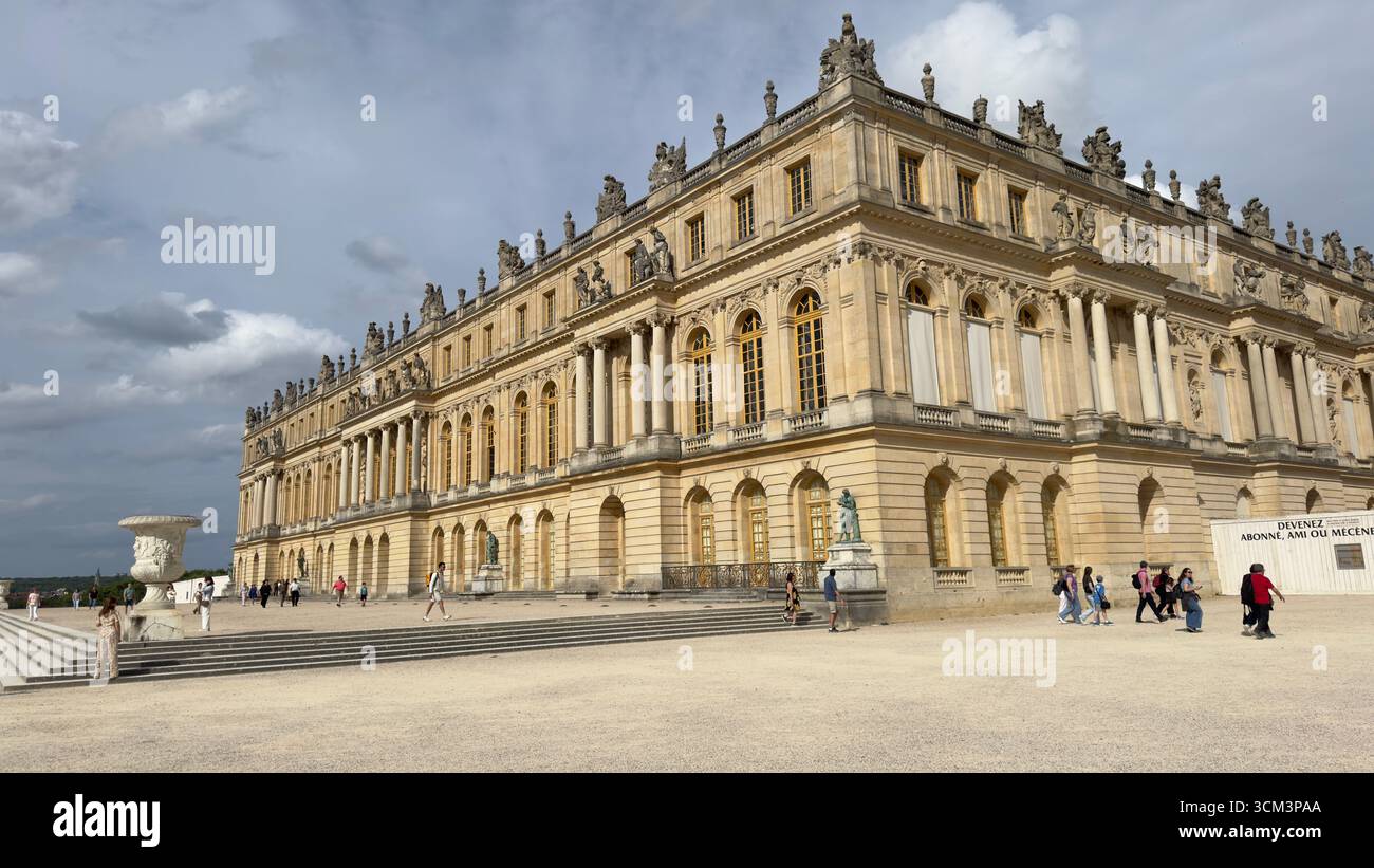 A grand, ornate palace with a pale yellow facade and numerous windows ...
