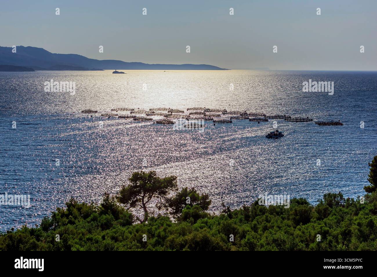 Lake landscape with fish farm, restaurant and mountains in Ksamil, southern Albania Stock Photo