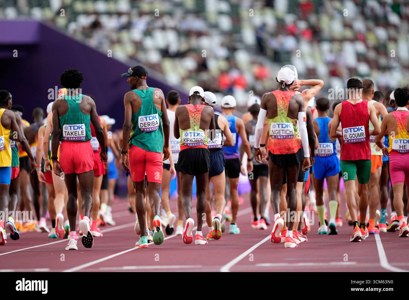 Runners Back View Starting Line Runners walk back to the start line after a false start in the men's ...