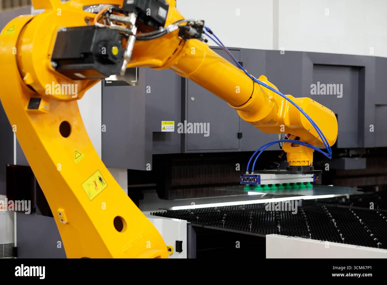 Robot loading steel sheets in press brake machine. Selective focus. Stock Photo