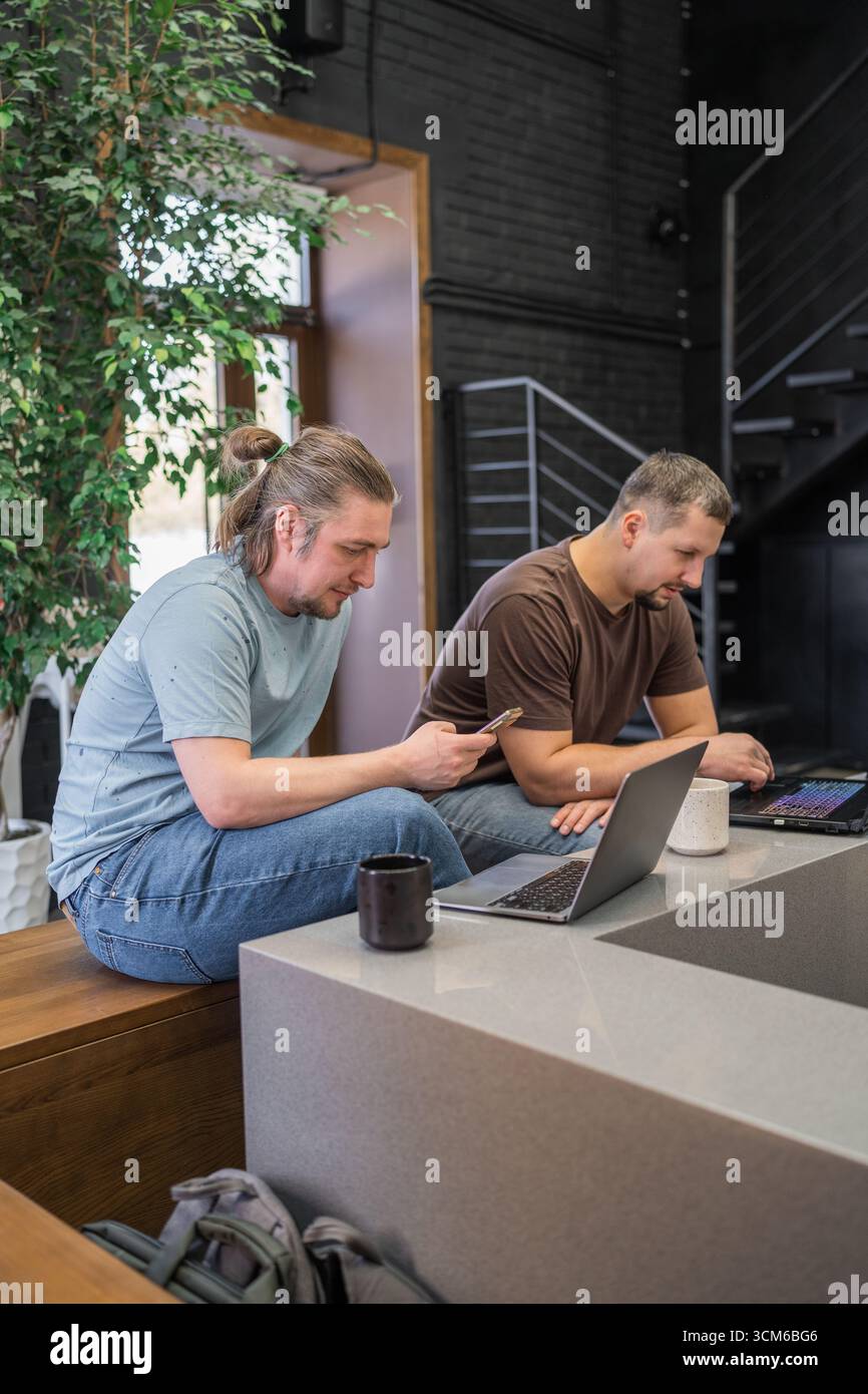 Two It Software engineers working on project and programming in coffee shop. Business people concept. Stock Photo