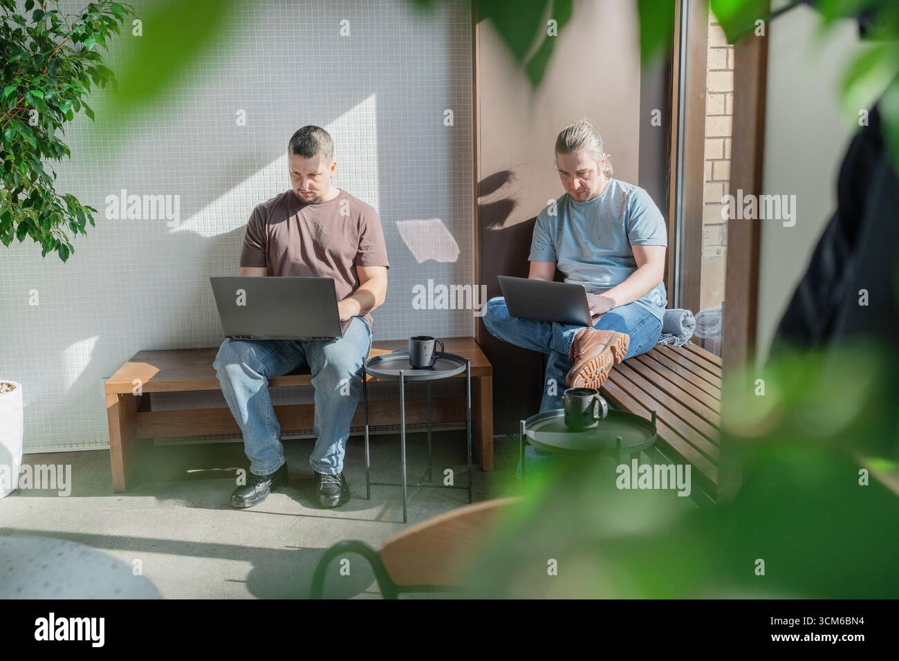 Two It Software engineers working on project and programming in coffee shop. Business people concept. Stock Photo