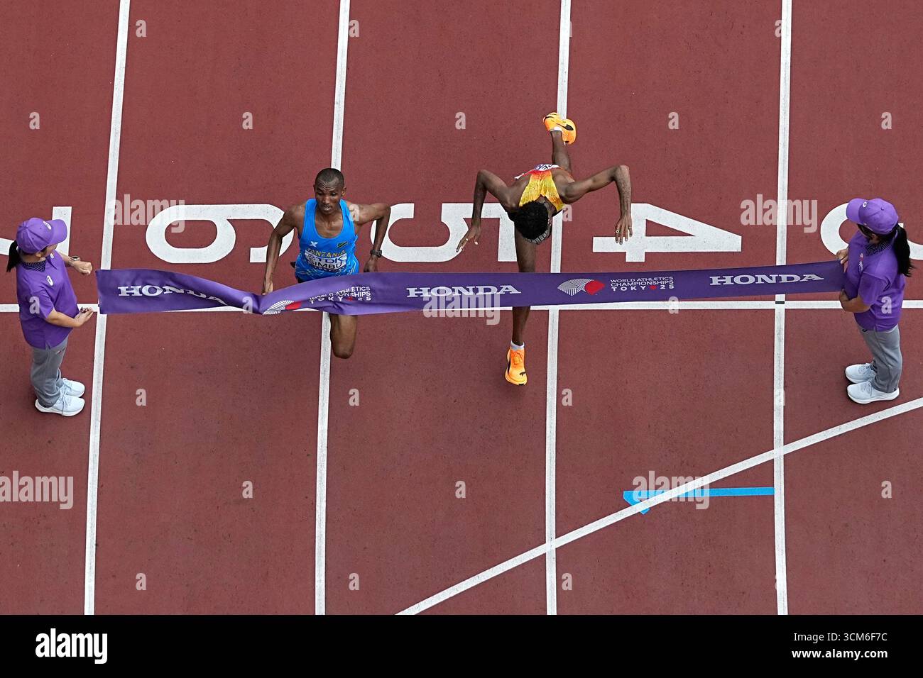 Tanzania's Alphonce Felix Simbu, left, crosses the finish line ahead of ...
