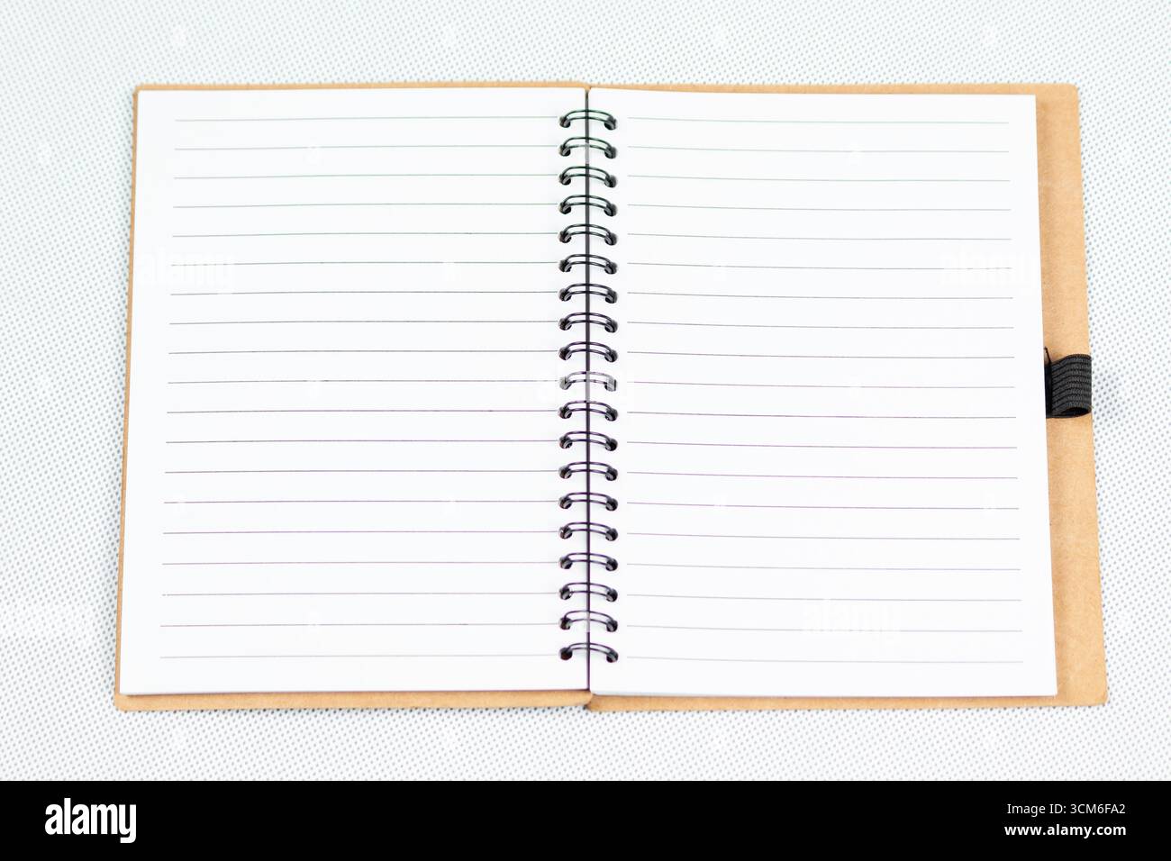 close up to a blanked notebook with a white lined sheets over a white background Stock Photo