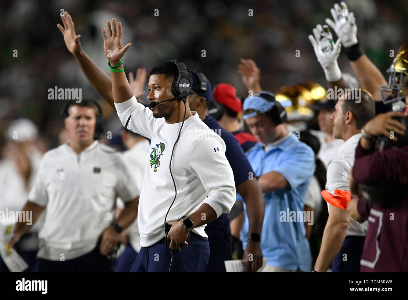 Notre Dame head coach Marcus Freeman signals to his players during the