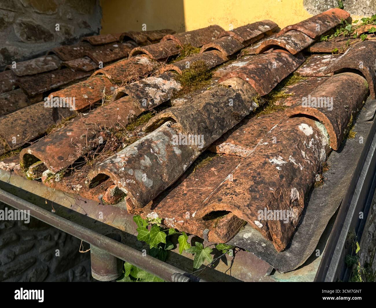 Worn weather beaten terracotta roof tiles in an Italian garden, Italy - Smartphone Captured Stock Image