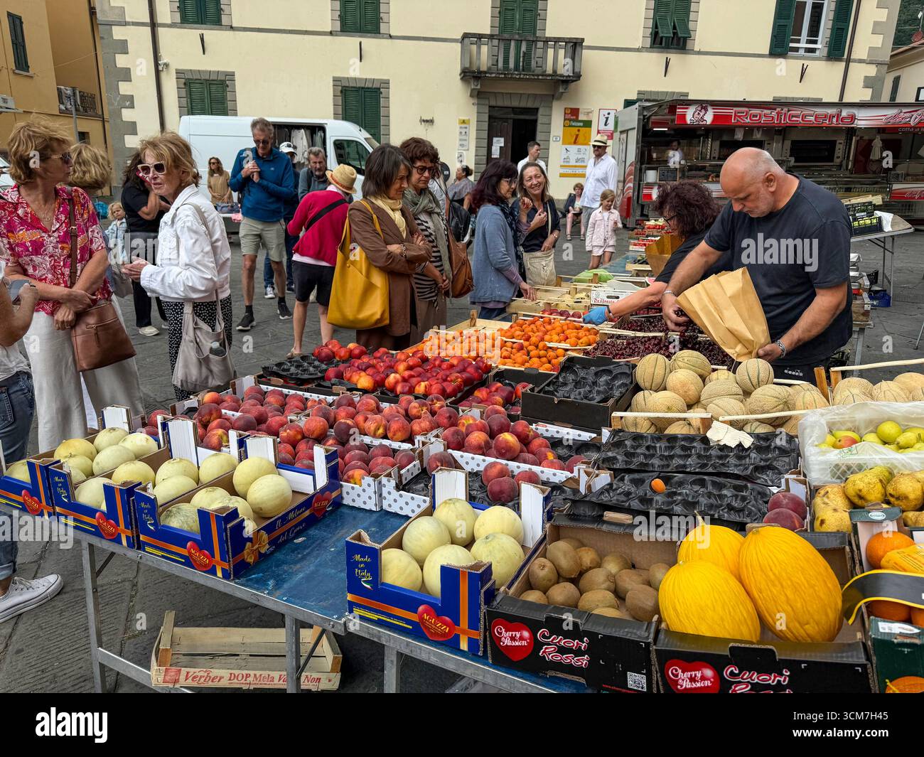 A busy fruit& veg stall at the weekly market held in front of the Chiesa del S. Jacopo e Antonio (Church of S. and Antonio on the 16th century Piazza - Smartphone Captured Stock Image