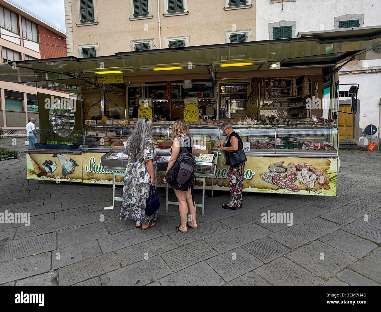A delicatessen van at the weekly market held on the 16th century Piazza Medice) in the medieval town of Fivizzano, a commune in the province of Massa - Smartphone Captured Stock Image
