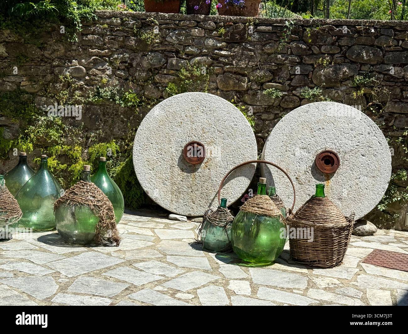 A pair of original millstone wheels with special carved grooves designed used for grinding chestnuts into flour at the 17th Century historic watermill - Smartphone Captured Stock Image