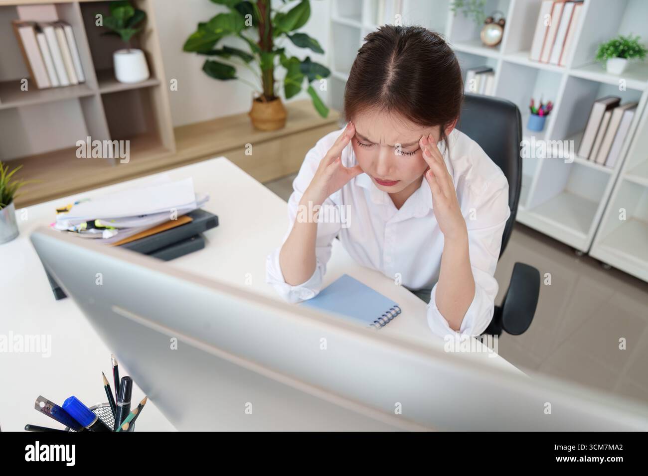 Office Stress. Young woman with headache while working on computer ...