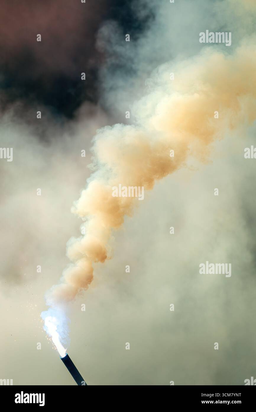 Bengal torch burning with dense smoke outdoors, flare torch emitting heavy smoke cloud. Selective focus. Stock Photo