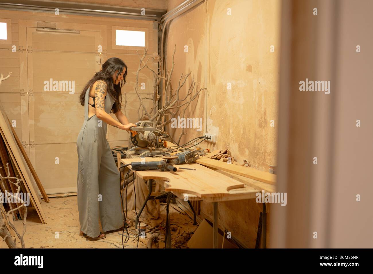 Carpenter using circular saw cutting wood plank in workshop Stock Photo
