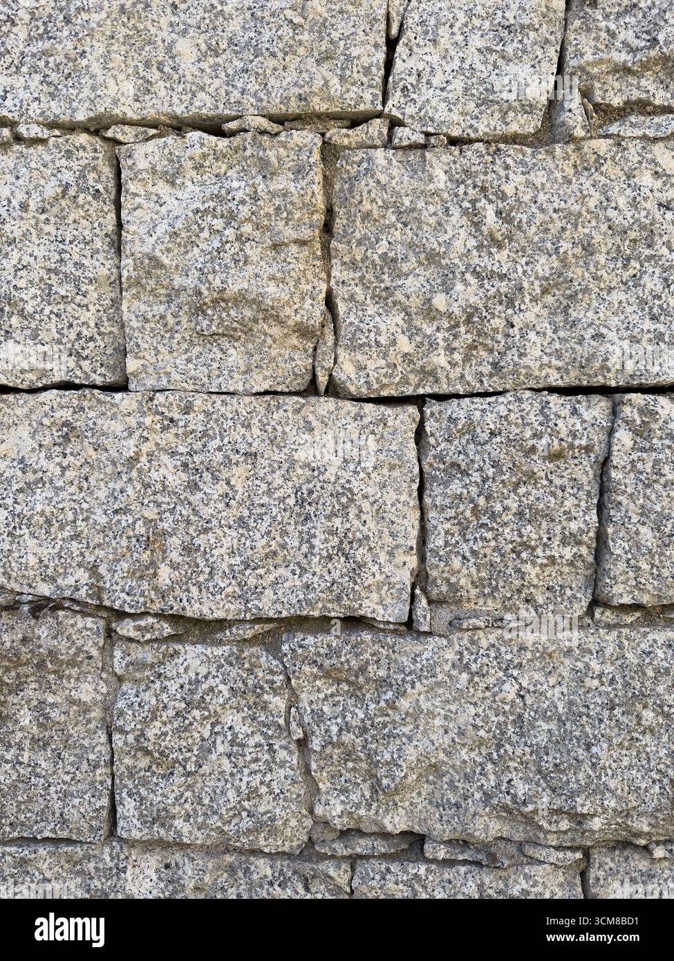 Rustic stone wall with multicolored natural rocks and mortar Stock Photo