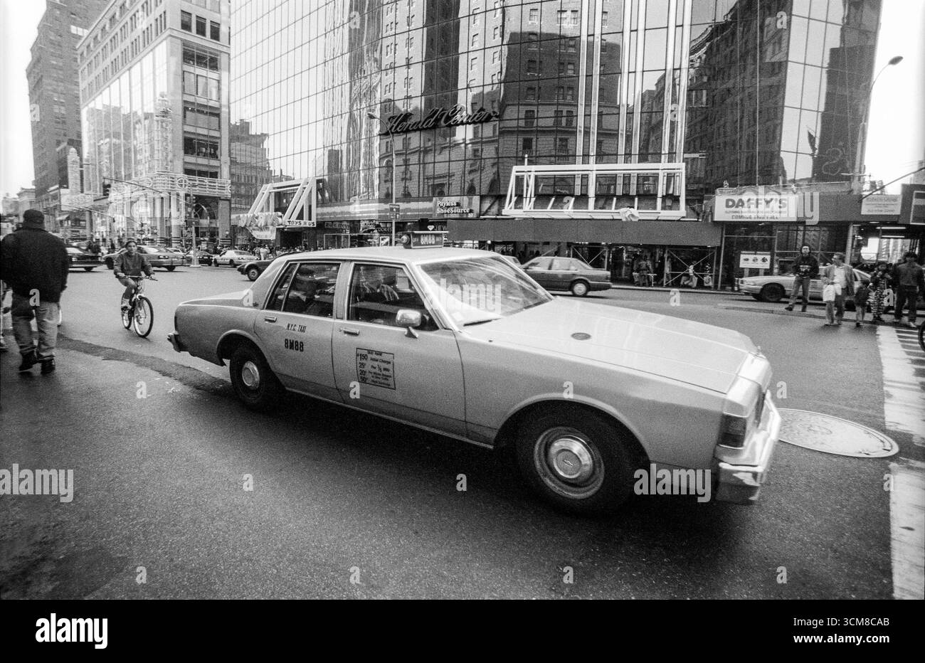 1994 black and white archive image of a New York taxi cab outside the Herald Centre on 6th Avenue at the junction with 34th Street in Manhattan. Stock Photo