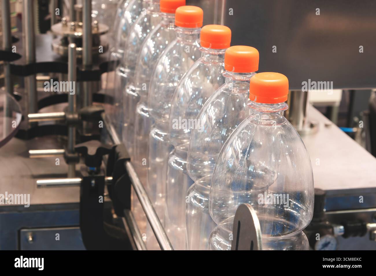Transparent plastic bottles on a conveyor belt for bottling drinks Stock Photo