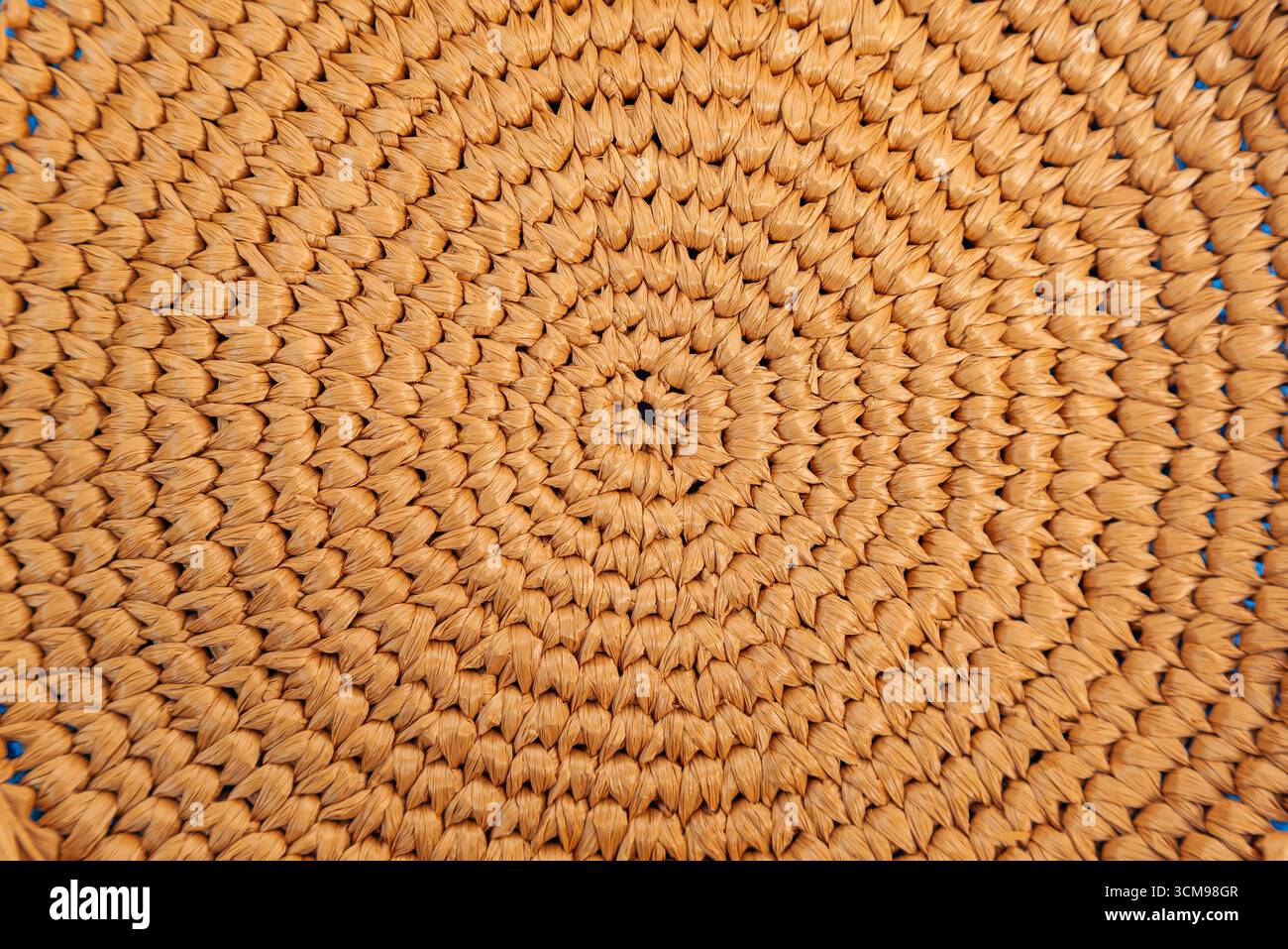 Circular weaving from natural raffia, close up. Stock Photo