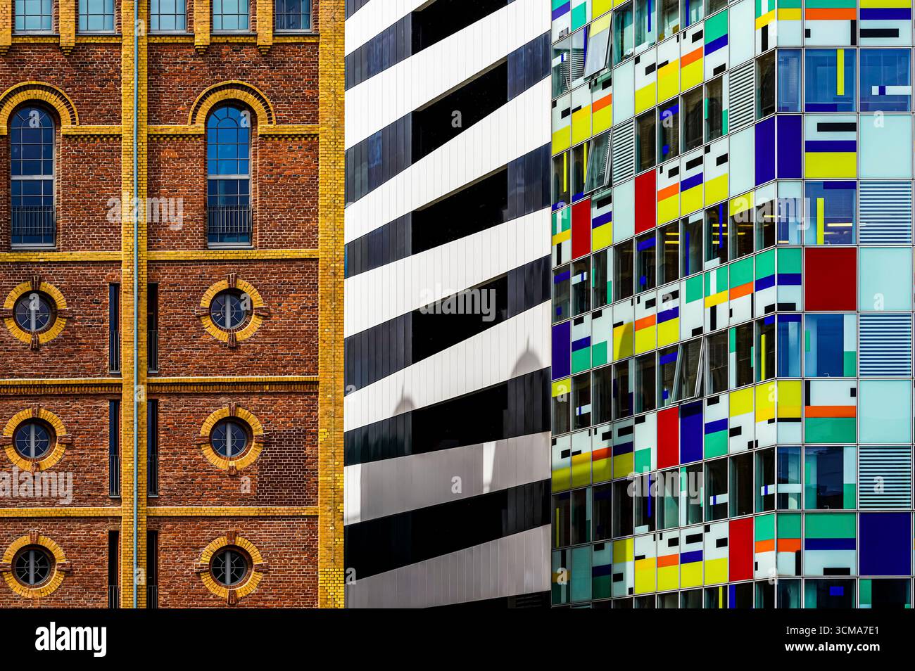 Germany, Düsseldorf, A Symphony of Eras: Three Facades - Two Buildings in the Media Harbor Düsseldorf. At first glance, the photo looks like a straight collage consisting of 3 vertical parts, but it is a real scene taken from a specific perspective, to show different three-dimensional structures on a two-dimensional plane. Stock Photo