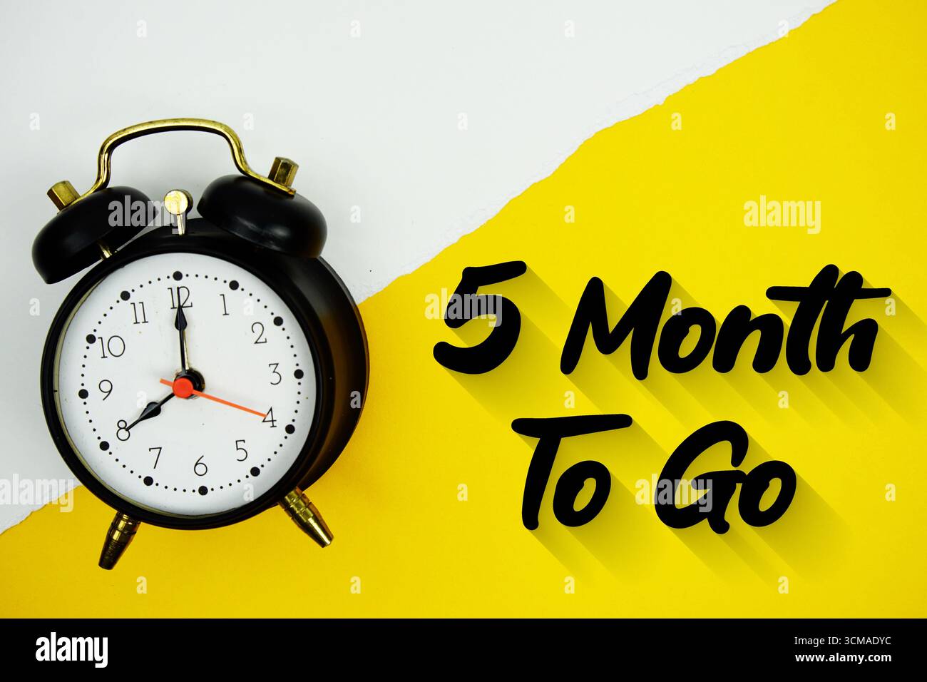 5 Month To Go text and alarm clock on yellow background Stock Photo - Alamy