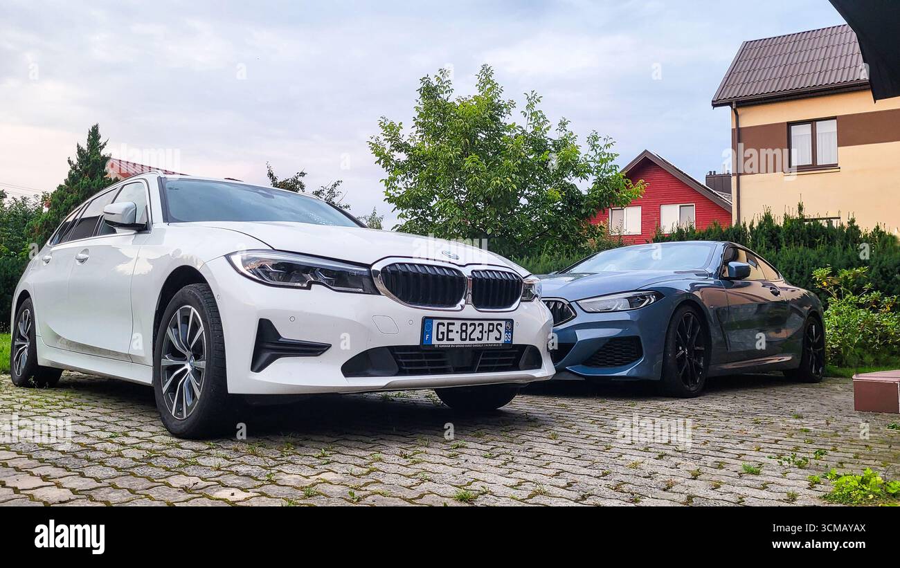 Vilnius, Lithuania - 2024-07-27 - Family car park with BMW 3 Series and BMW 8 Series in private house yard Stock Photo