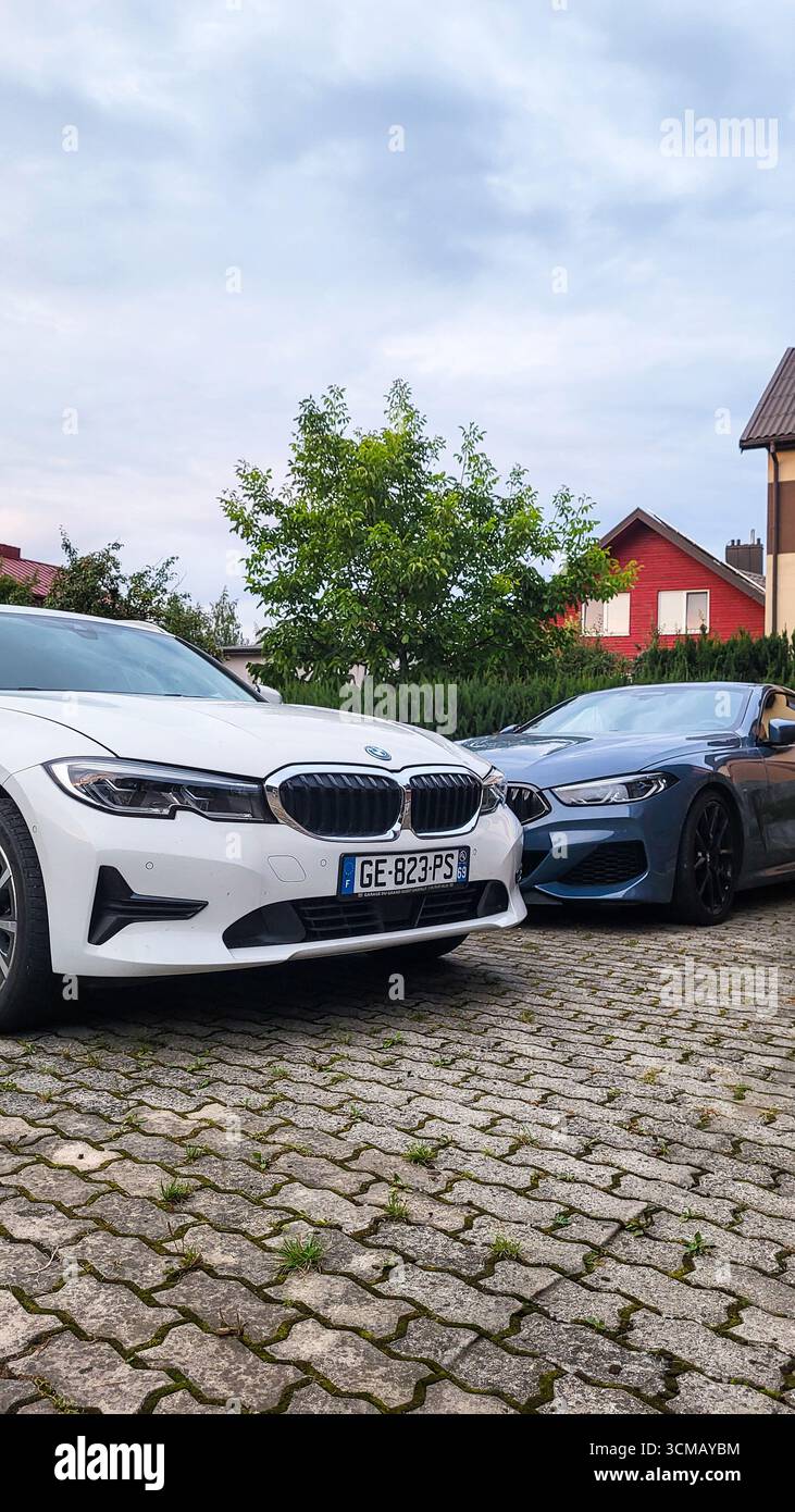 Vilnius, Lithuania - 2024-07-27 - Family car park with BMW 3 Series and BMW 8 Series in private house yard Stock Photo
