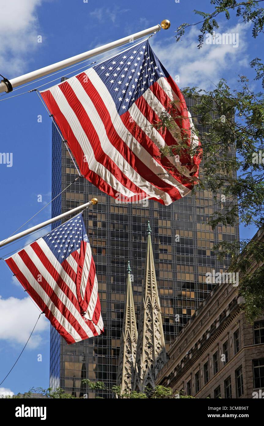 Waving USA flags, behind towers of St Patrick's Cathedral, Manhattan ...