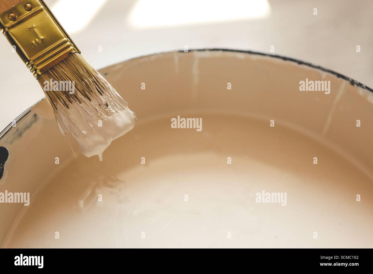 Paint brush resting on paint tin viewed from above. Stock Photo