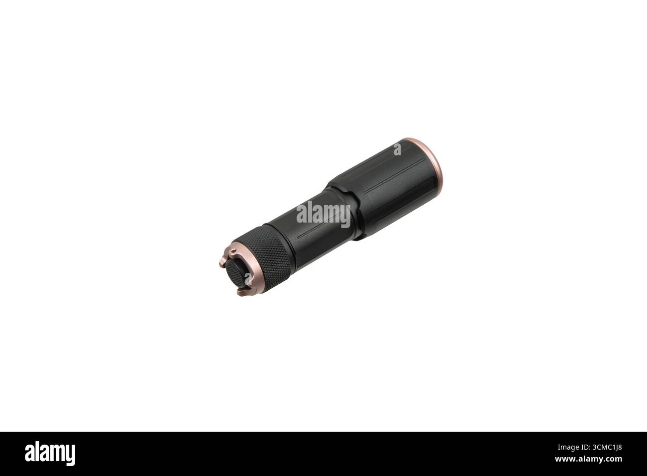 A compact black and copper-colored LED flashlight, isolated on a white background. Stock Photo