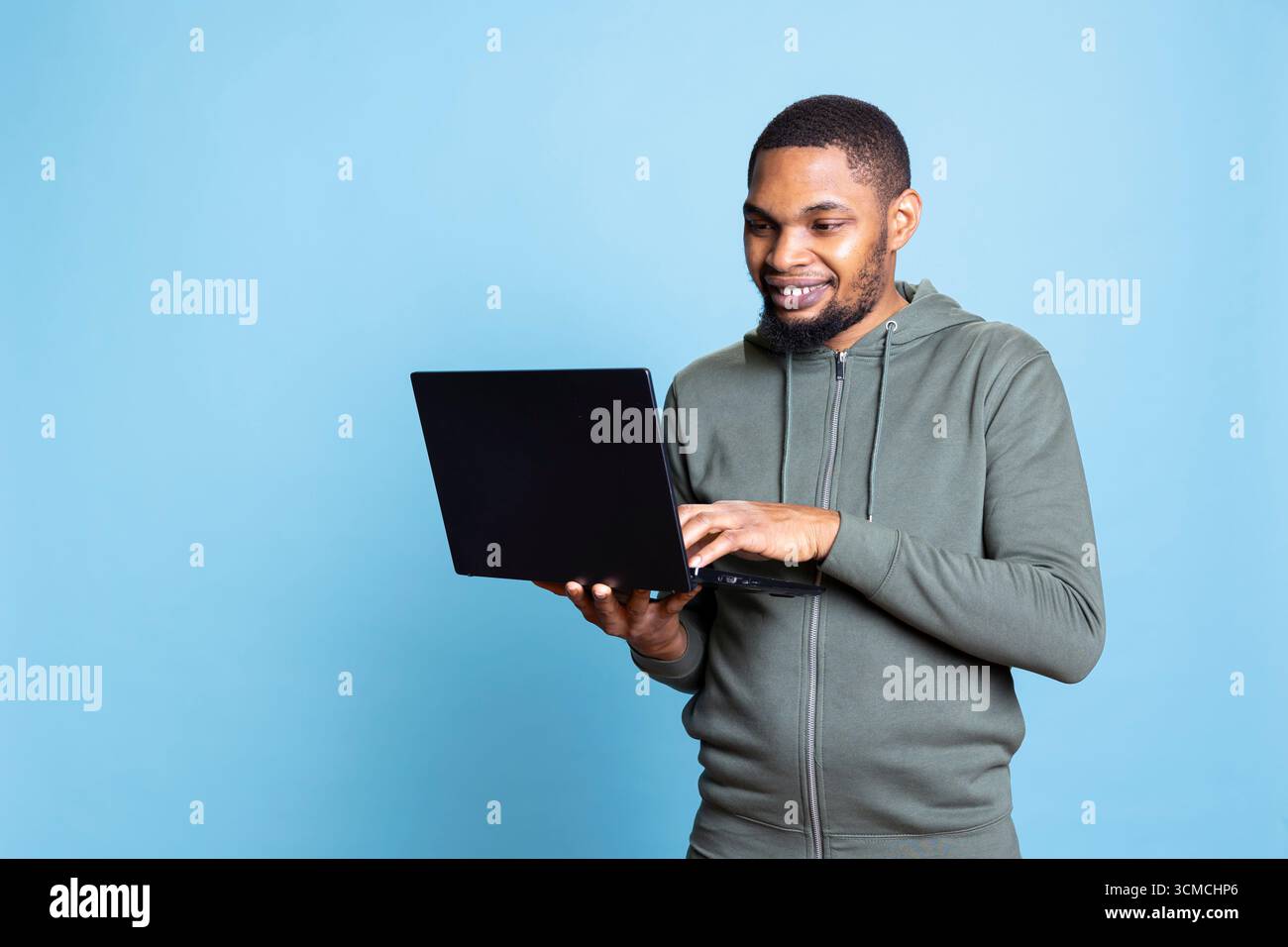 African american man typing on laptop keyboard and checking emails ...