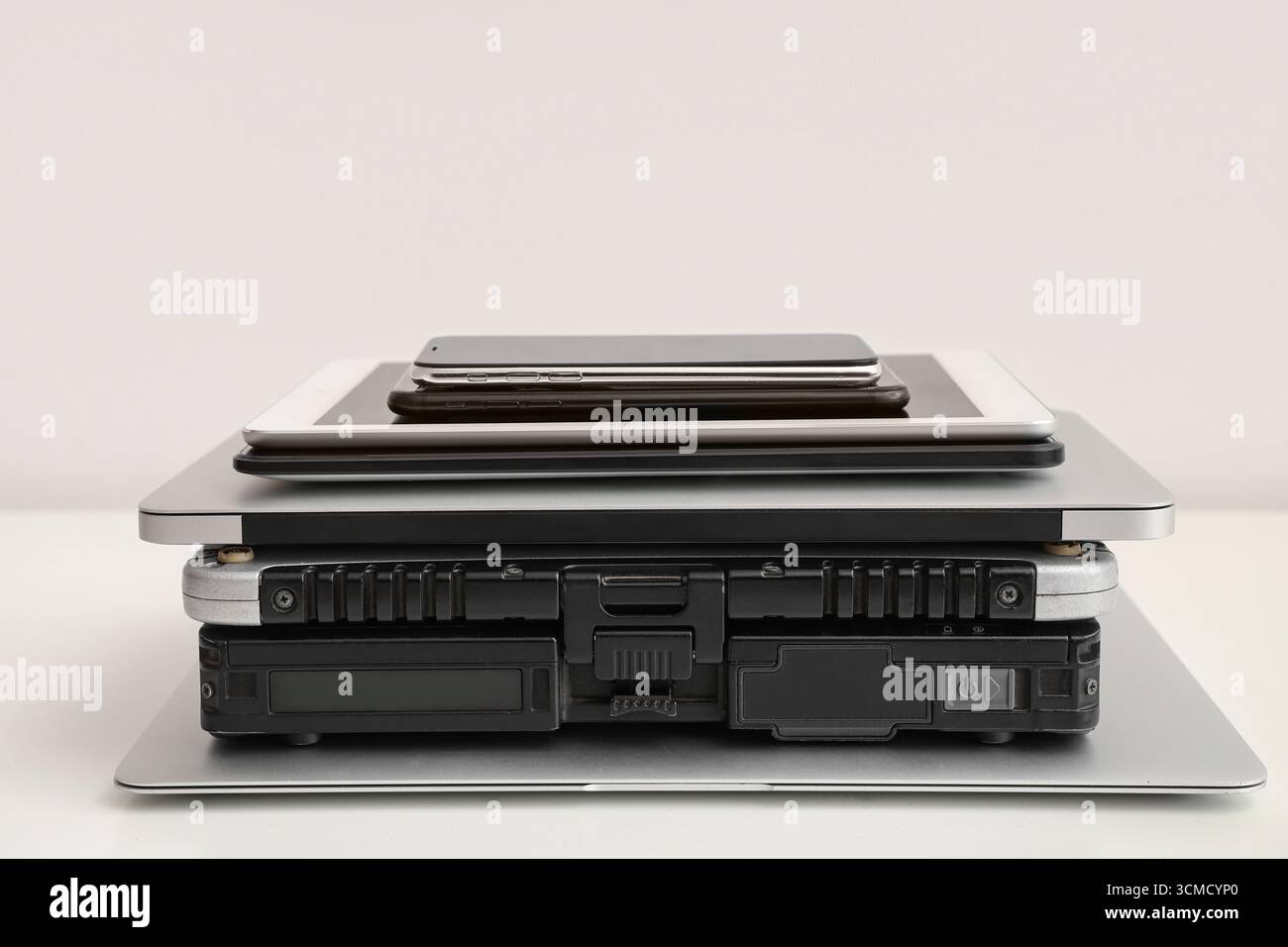 Stack of different modern gadgets on light background Stock Photo