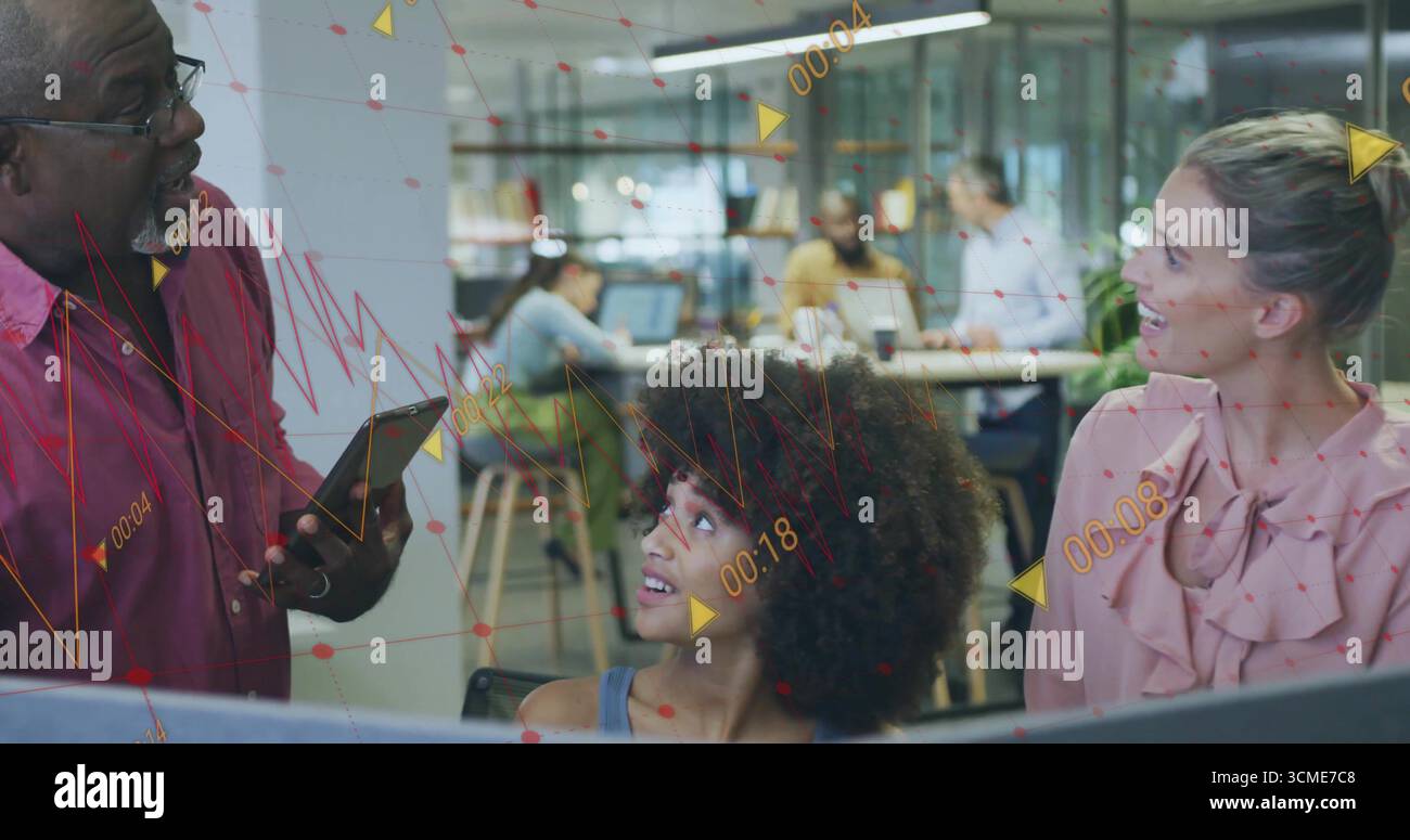 Three colleagues collaborating on data overlays in open-plan office, with tablet and laptops Stock Photo