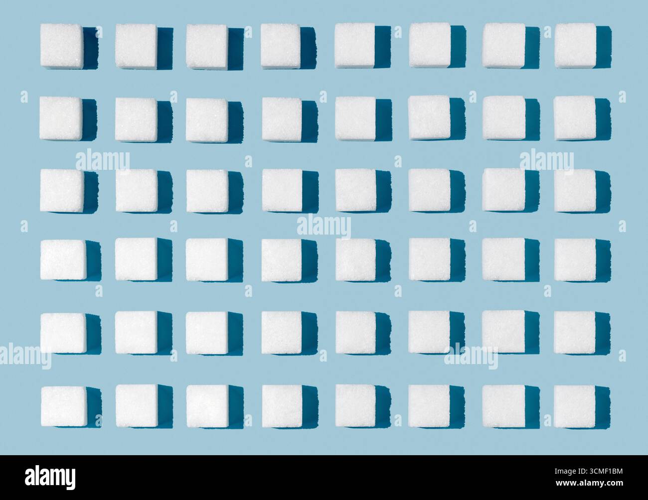 White sugar cubes arranged for effect on blue background Stock Photo