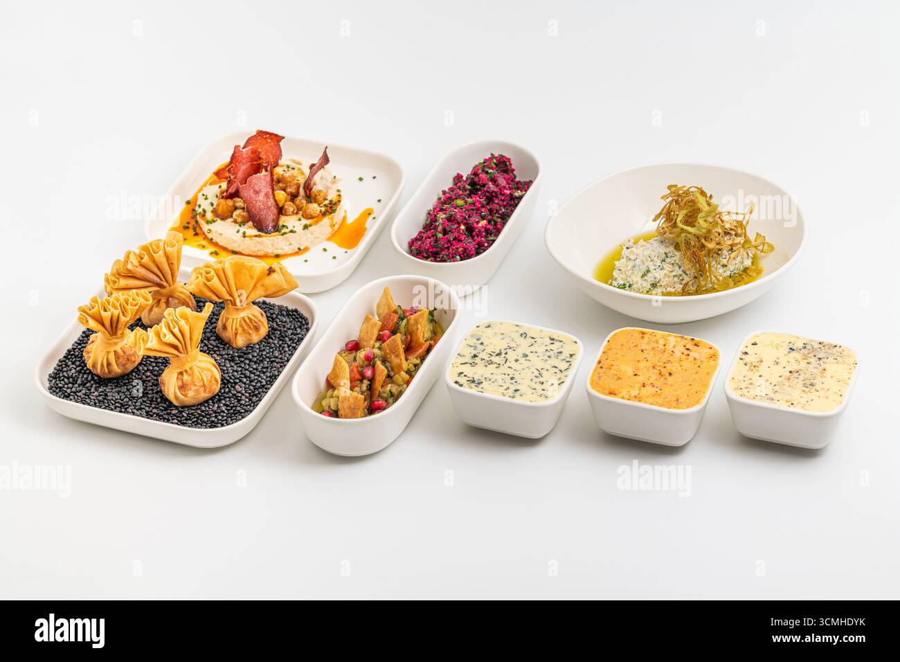 Assorted appetizers with dips, spreads, and vegetables on table Stock Photo
