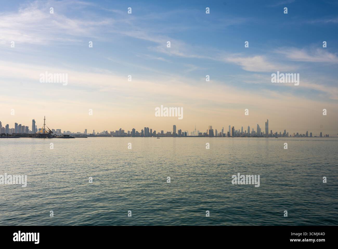 View of Kuwait City skyline across the calm waters of the Arabian Gulf ...