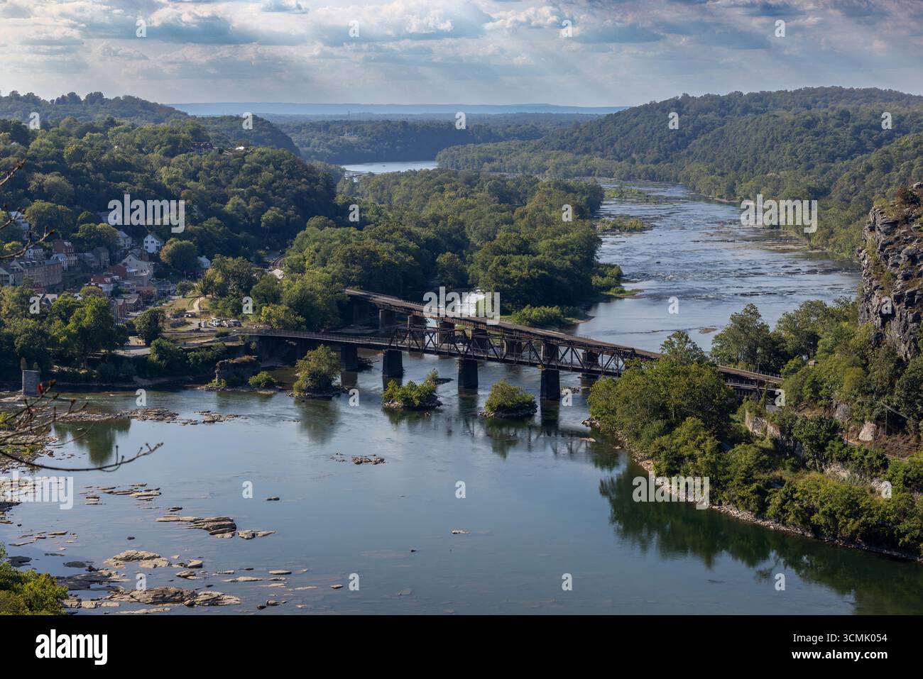The Shenandoah and Potomac rivers converge at historic Harpers Ferry in this breathtaking high-angle shot, capturing the iconic town and bridges. Stock Photo
