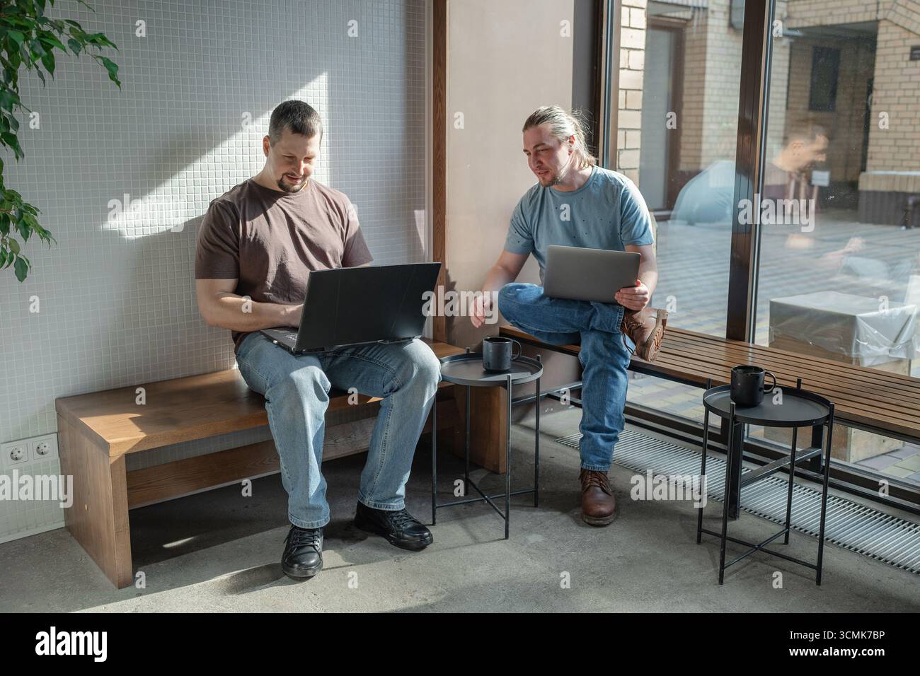 Two It Software engineers working on project and programming in coffee shop. Business people concept. Stock Photo