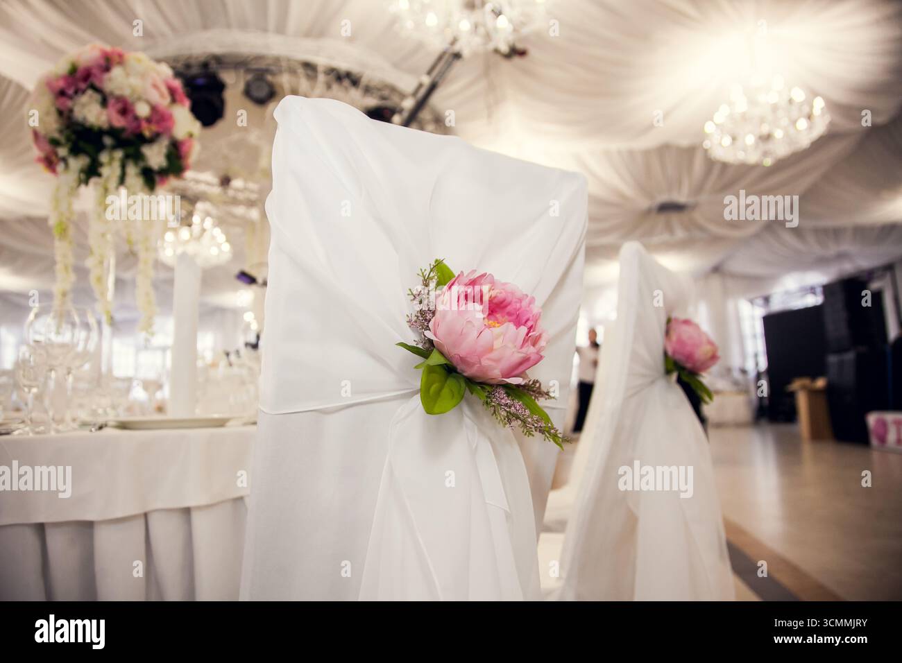 Enhanced Reseption Beautiful white chair covers adorned with pink peonies enhance the ...