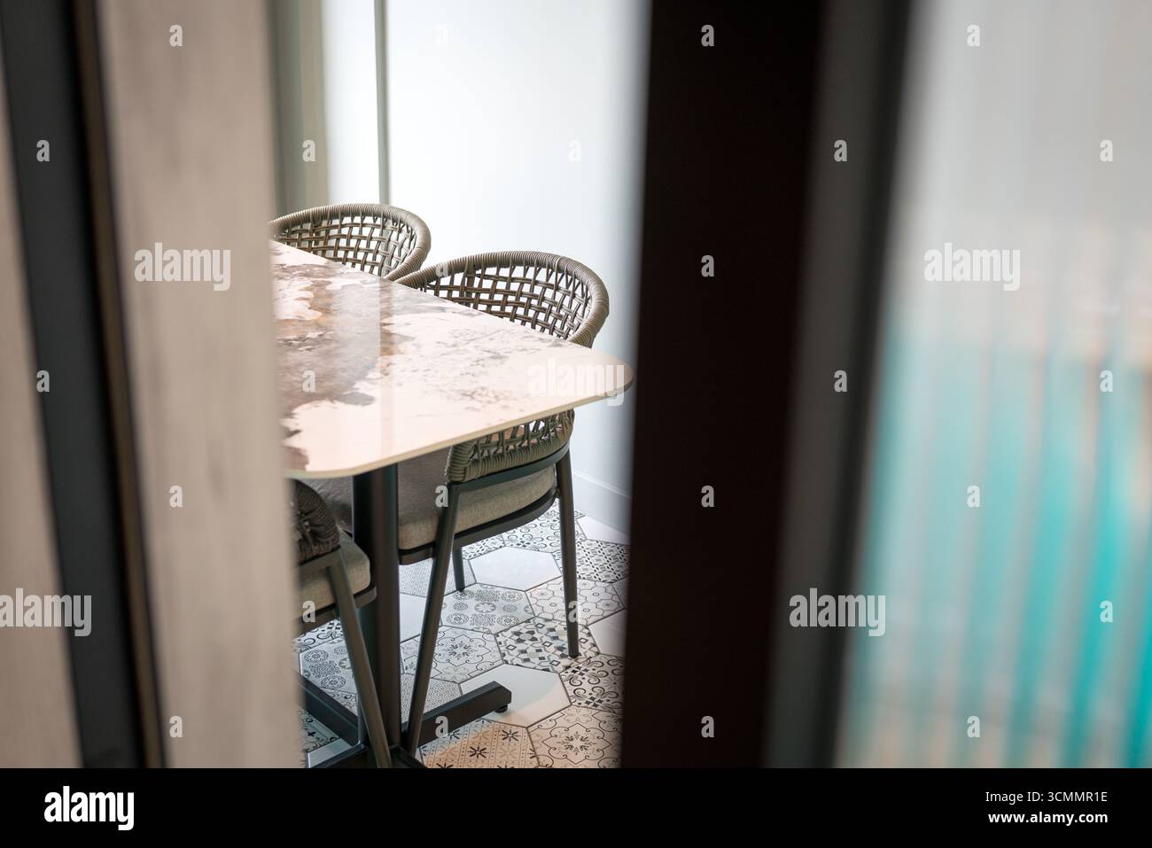 A glimpse of dining table and chairs through a door opening in a modern apartment. Stock Photo