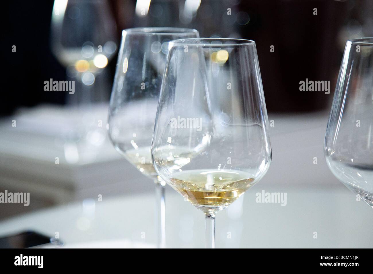 On the table sit three wine glasses filled with white wine Stock Photo ...