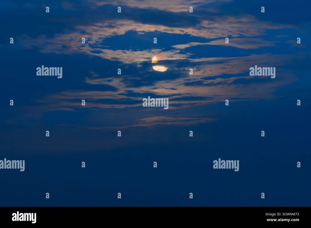 Full moon hiding behind the clouds Stock Photo