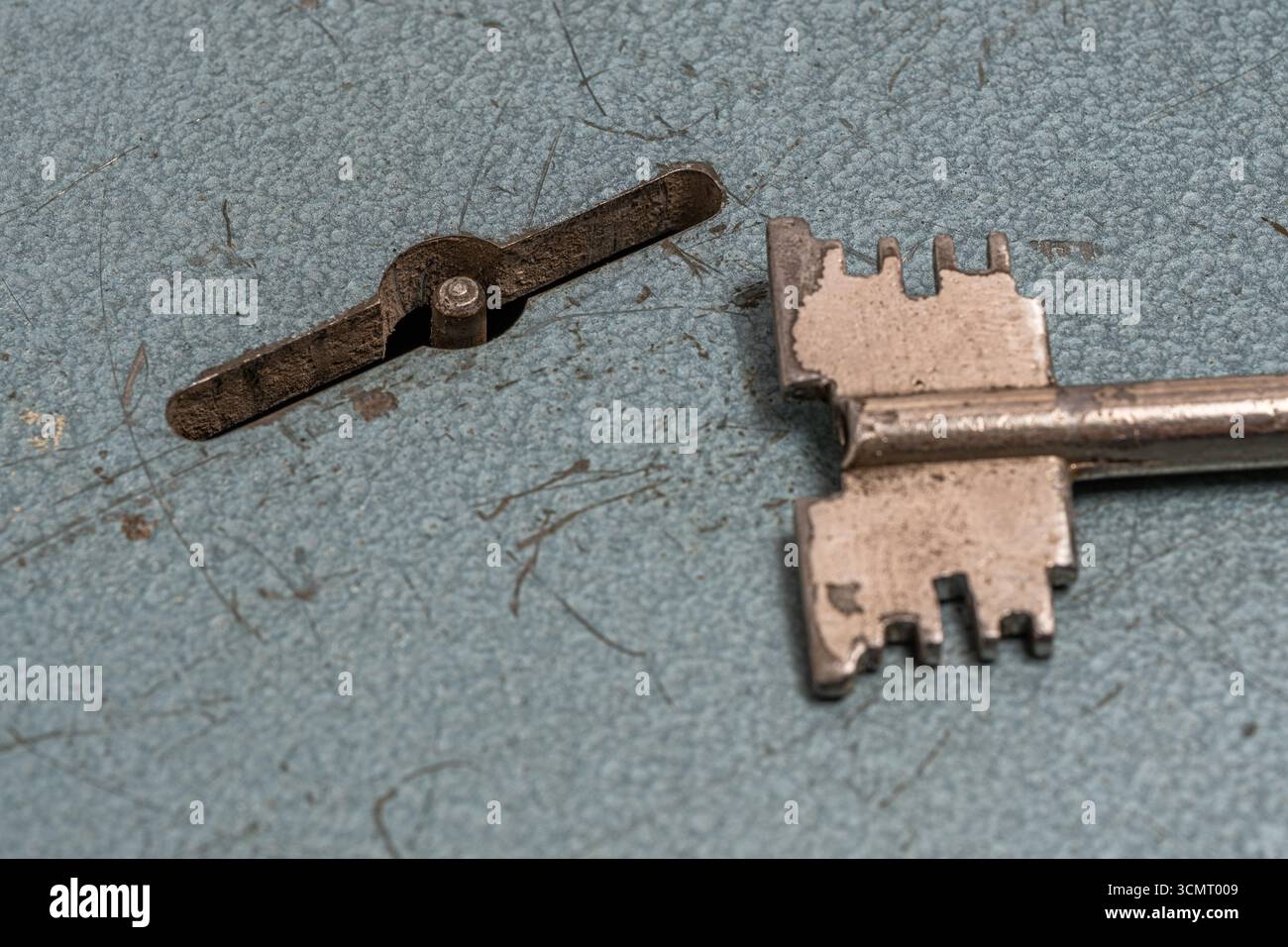 Old key is lying next to keyhole on lock Stock Photo