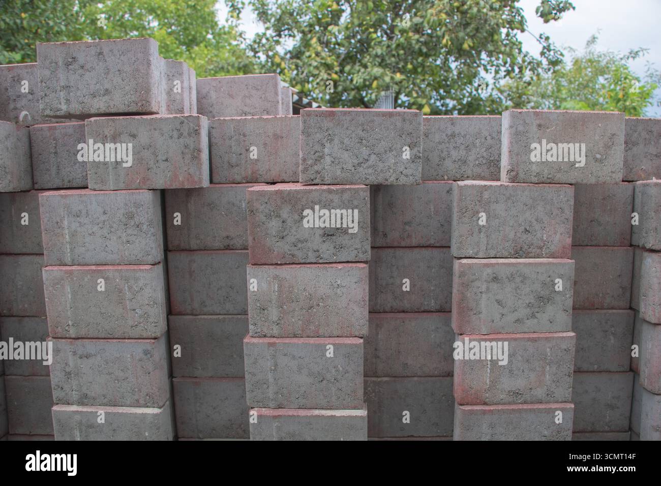 Stack of concrete bricks arranged in rows outdoors, construction material background for building industry, architecture and infrastructure projects Stock Photo
