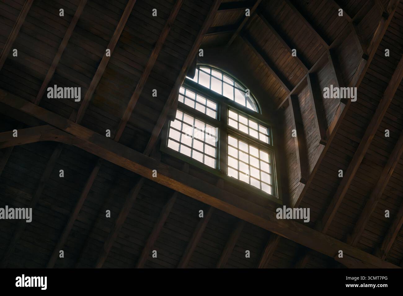 Low angle view of daylight coming through arched window in old wood ...